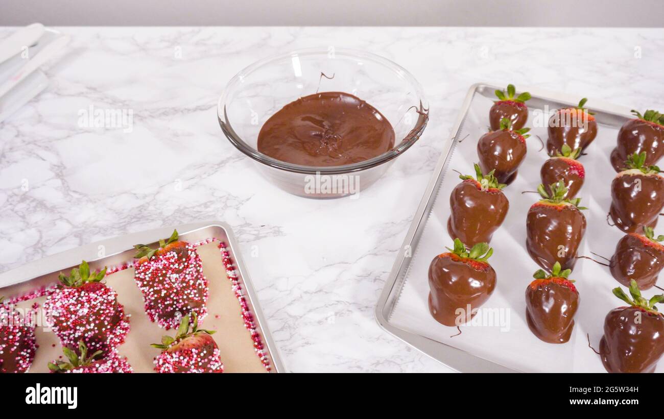 Step by step. Dipping organic strawberries into melted chocolate Stock