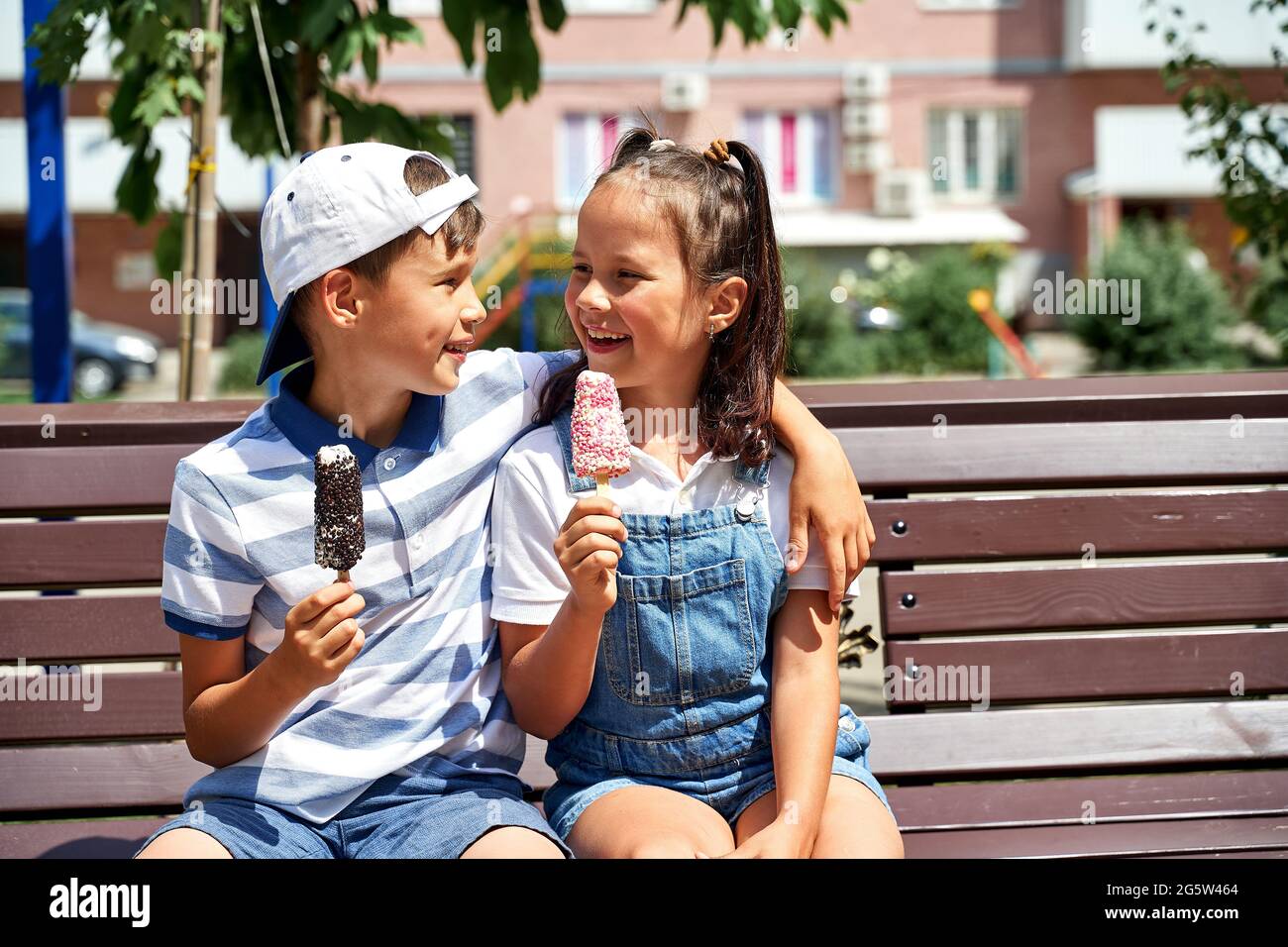 beautiful little boy and girl eating ice cream in summer Stock Photo