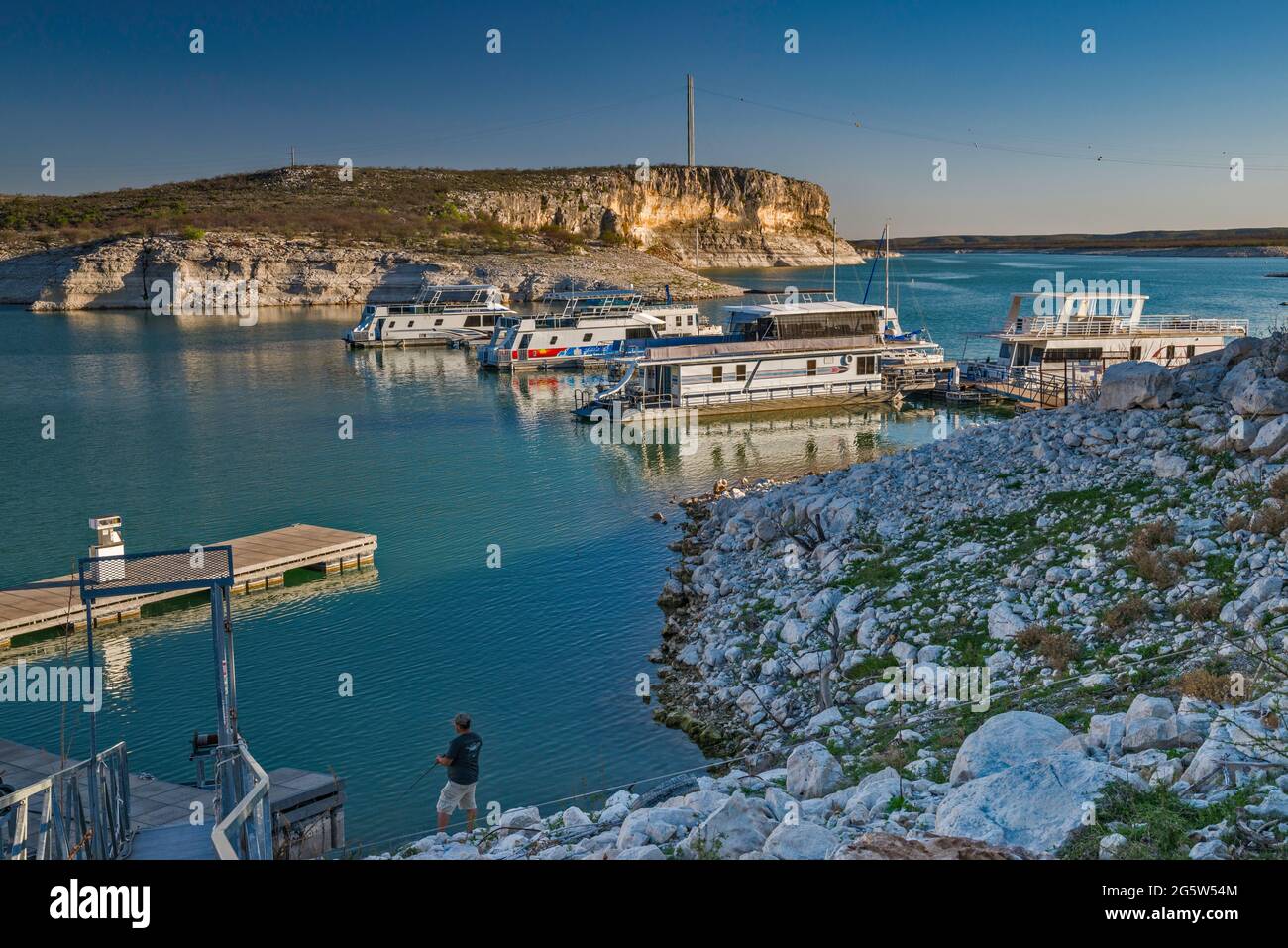 Boats moored at marina near Rough Canyon Cliffs, Amistad Reservoir, sunset, near Del Rio, Texas, USA Stock Photo