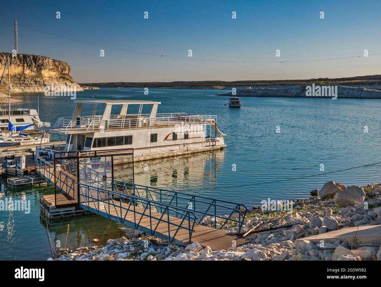 Boats moored at marina near Rough Canyon Cliffs, Amistad Reservoir, sunset, near Del Rio, Texas, USA Stock Photo