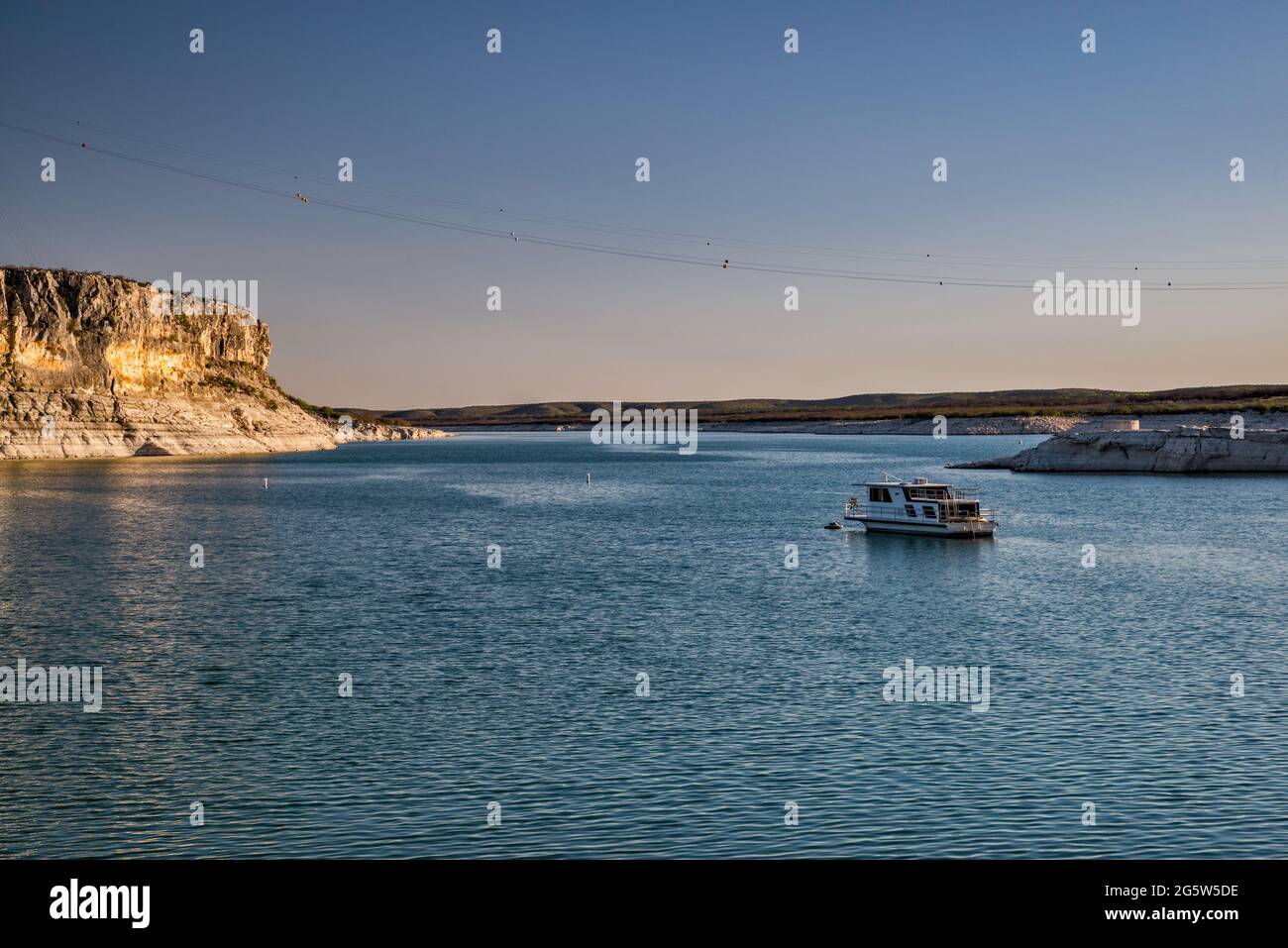 Boat anchored near Rough Canyon Cliffs, Amistad Reservoir, sunset, near Del Rio, Texas, USA Stock Photo