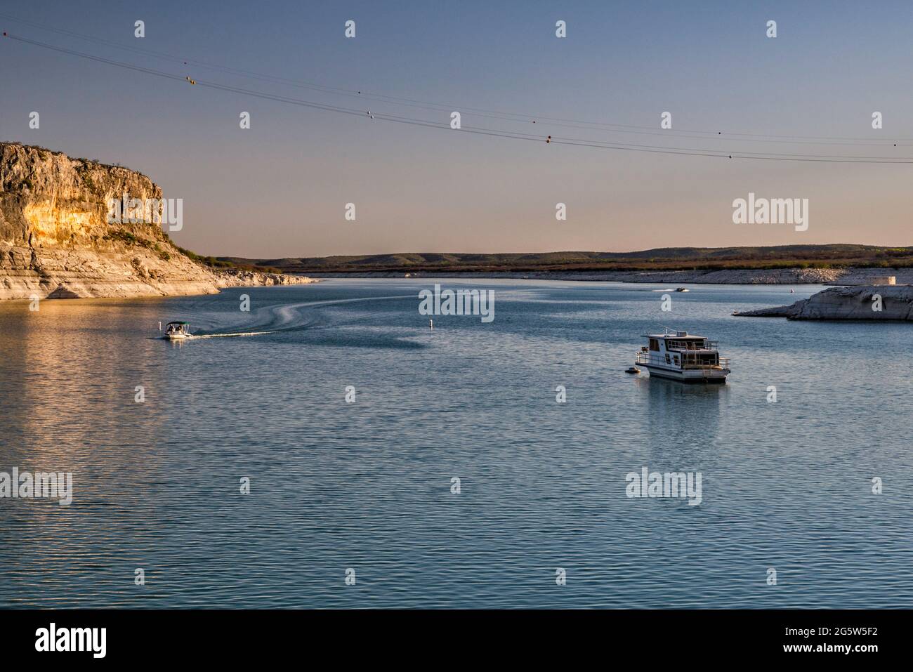 Boat anchored near Rough Canyon Cliffs, Amistad Reservoir, sunset, near Del Rio, Texas, USA Stock Photo