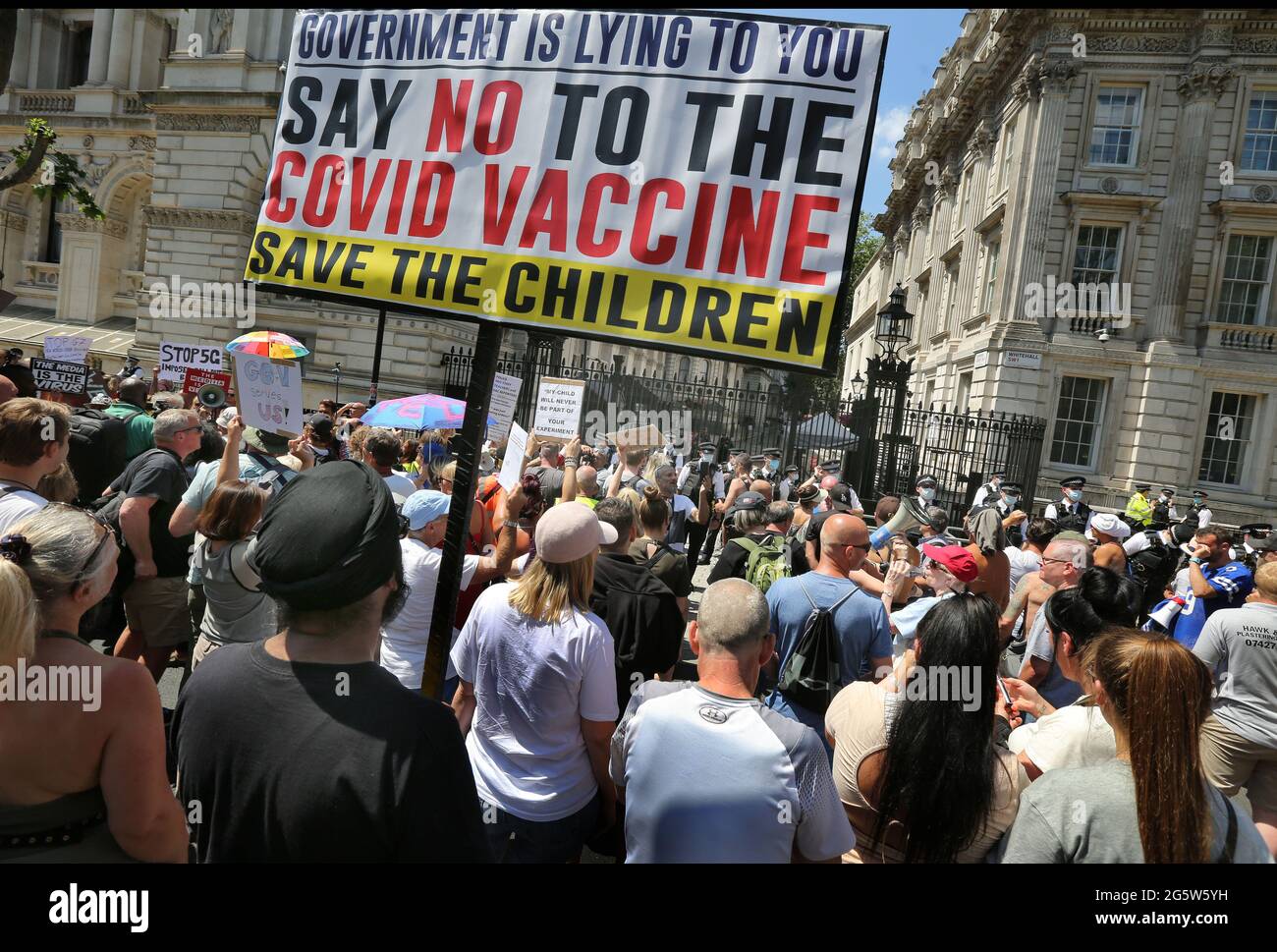 London, UK. 14th June, 2021. Protesters block Whitehall, and a large banner is seen reading ''Government is lying to you say no to the Covid Vaccine, Save the Children'' during the protest.Protesters gather outside Downing Street to protest against Boris Johnson's announcement of an extension of the lockdown regulations in the UK which they believe infringe their human rights they also protest against continued wearing of masks and being subjected to the vaccination program. Credit: Martin Pope/SOPA Images/ZUMA Wire/Alamy Live News Stock Photo