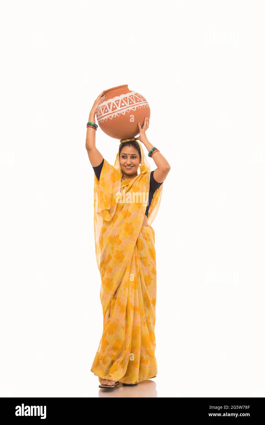 A woman standing with a matki on her head. Stock Photo