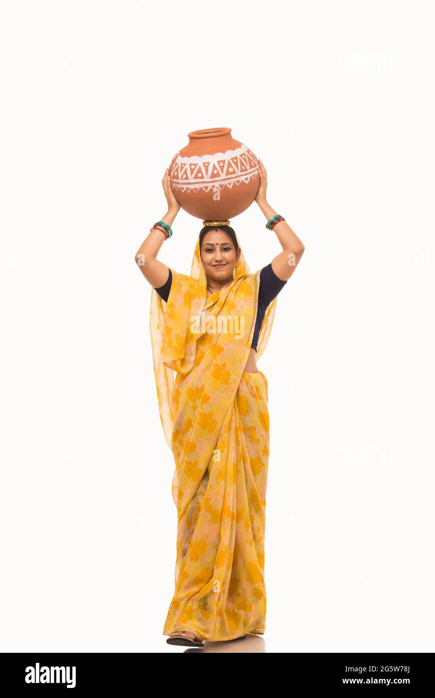 A woman standing with a matki on her head. Stock Photo