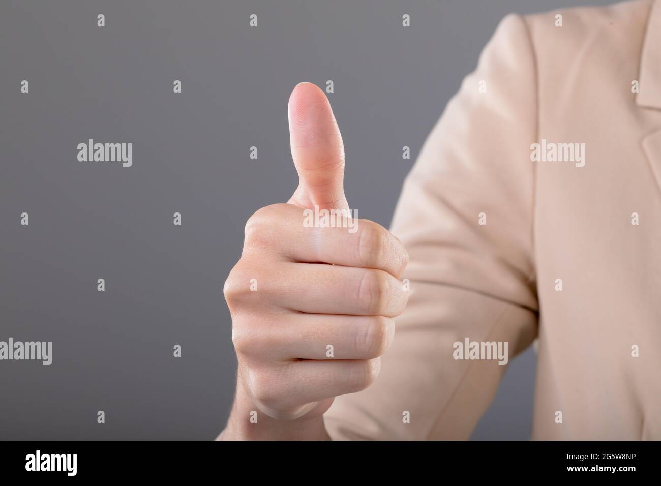 Midsection of caucasian businesswoman touching virtual interface on grey background Stock Photo