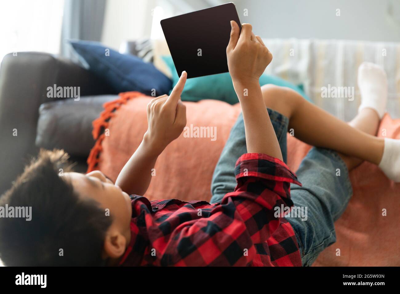 Asian boy using tablet with blank screen lying on floor at home Stock Photo