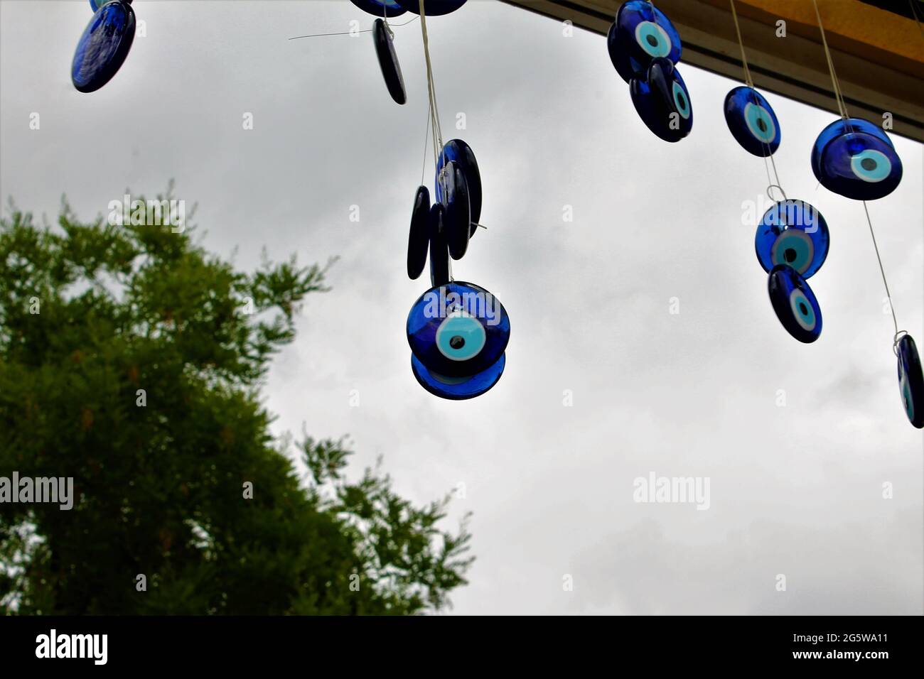 blue evil eye beads hung on a tree Stock Photo