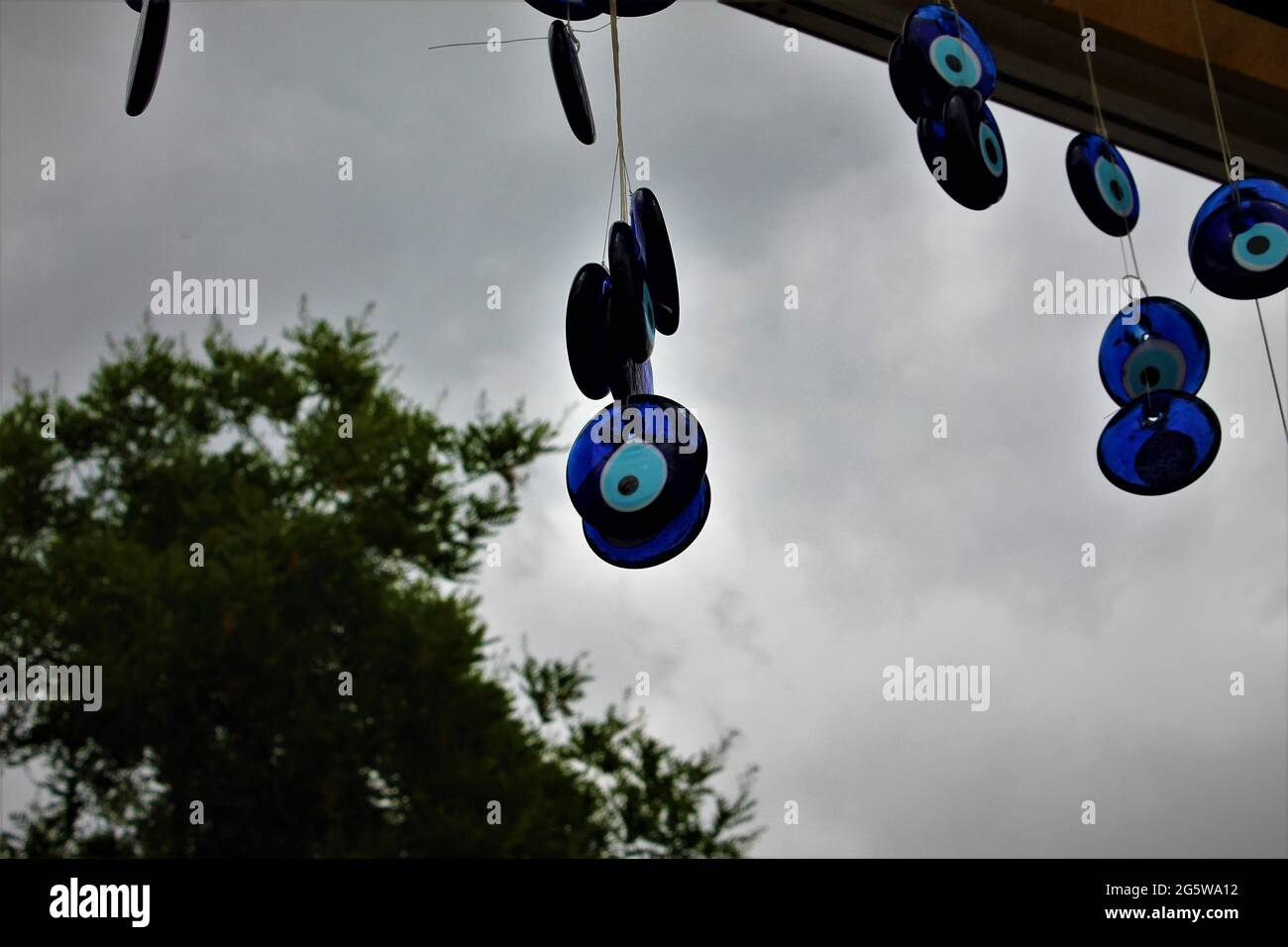 blue evil eye beads hung on a tree Stock Photo