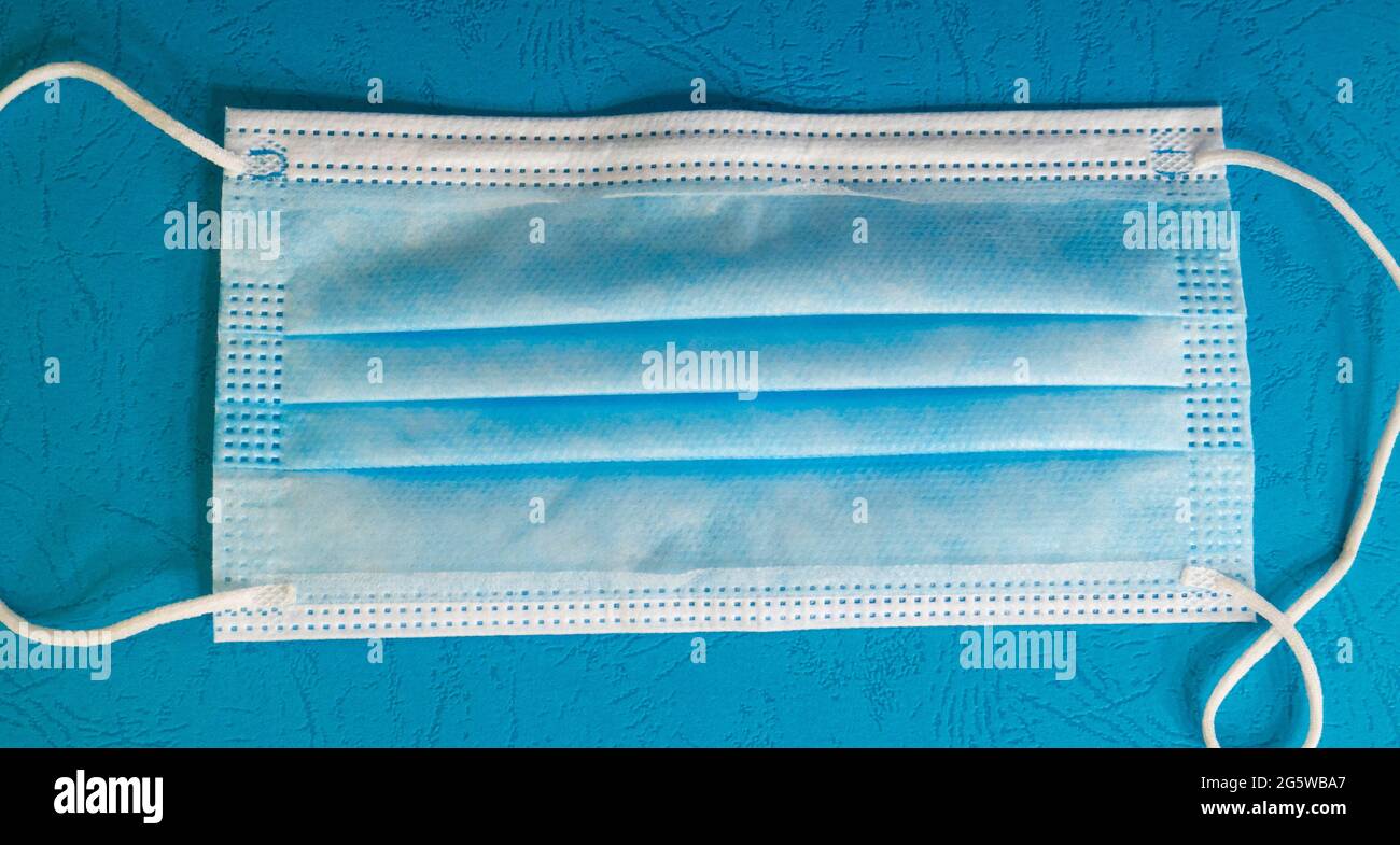 Blue medical mask on a blue background. Stock Photo