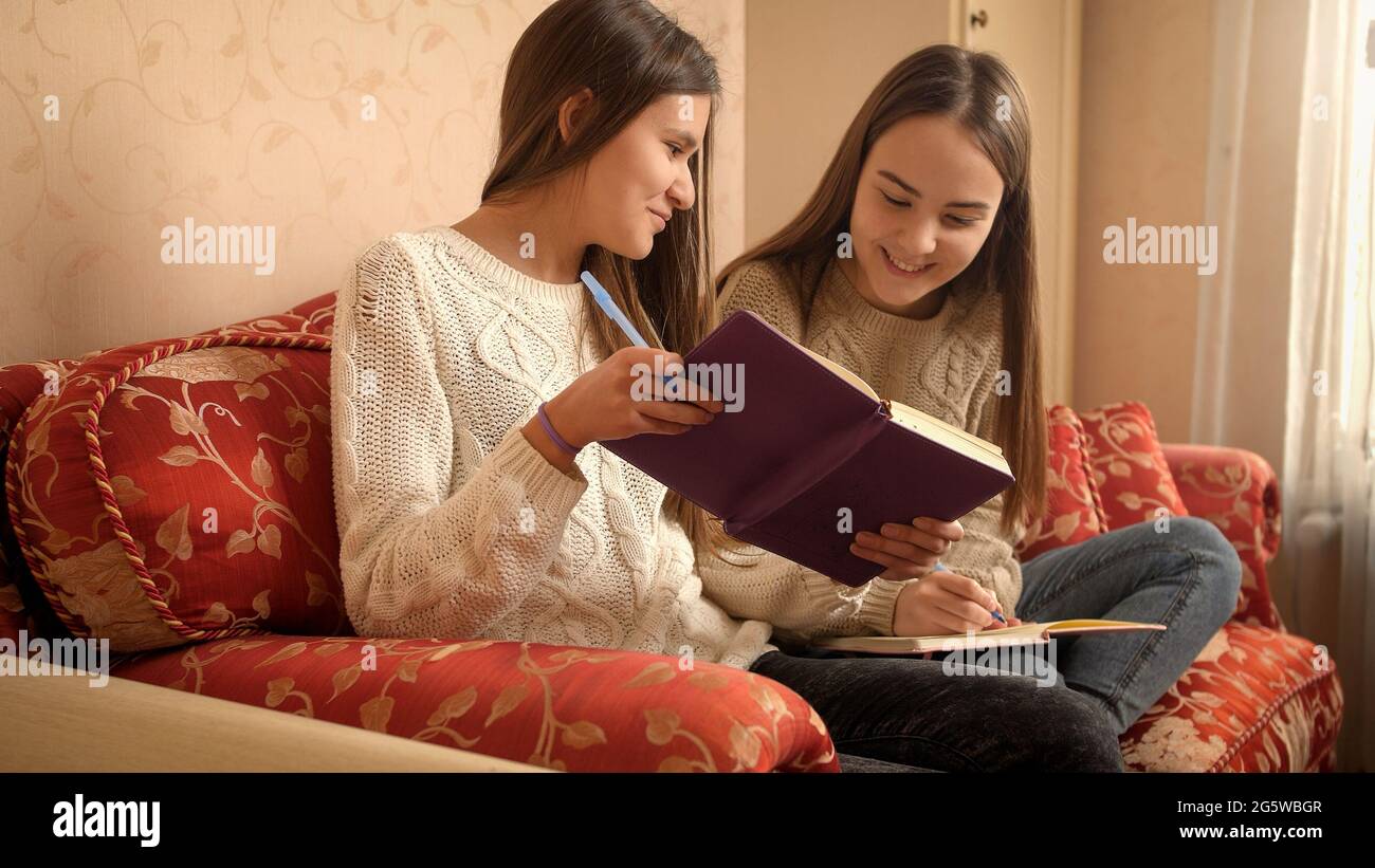 Two happy smiling girls smiling and laughing while doing homework and ...