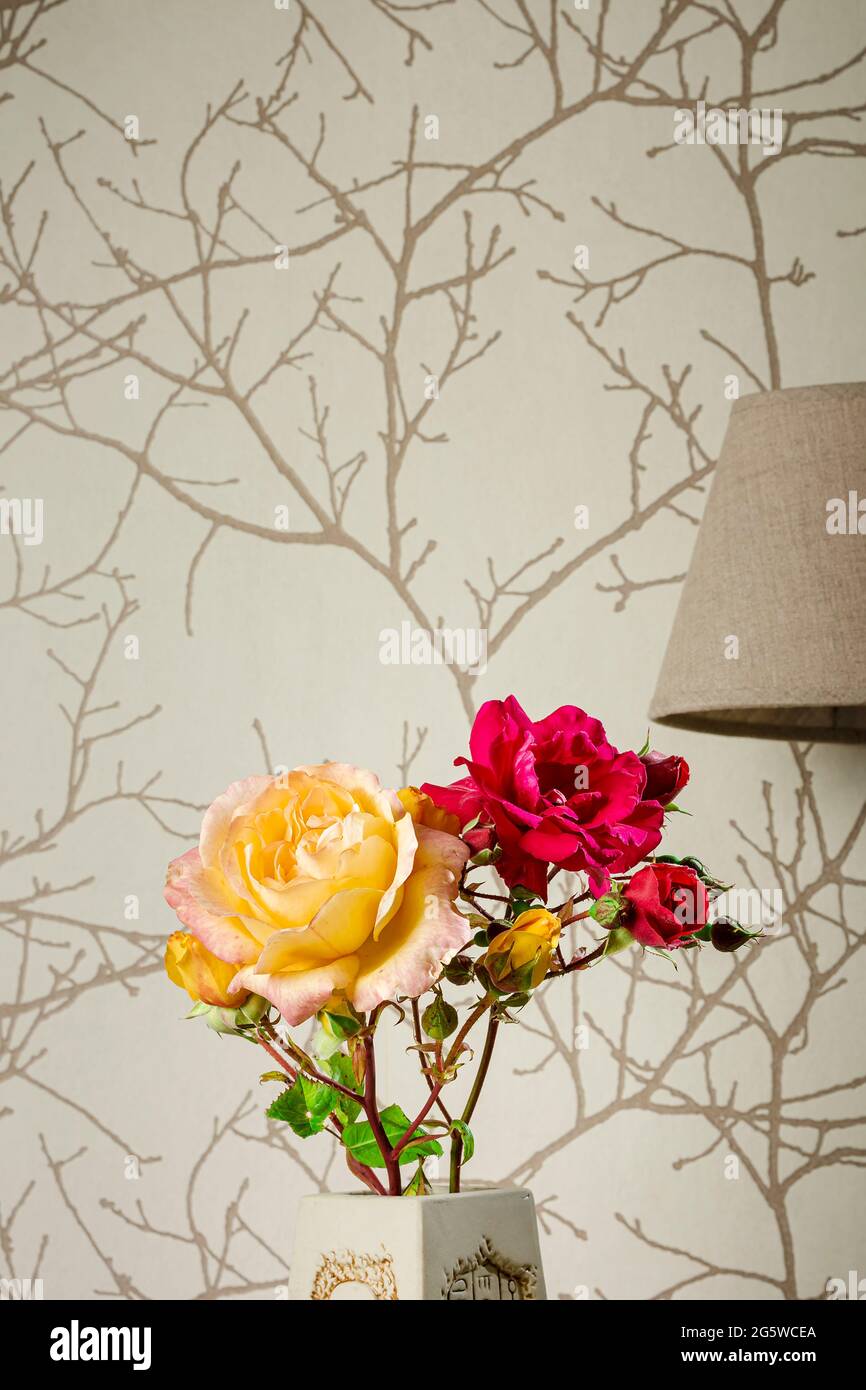 Photograph of a bouquet of roses with a lamp in the background.The photo has copy space to put text or whatever you want.It is a vertical shot. Stock Photo