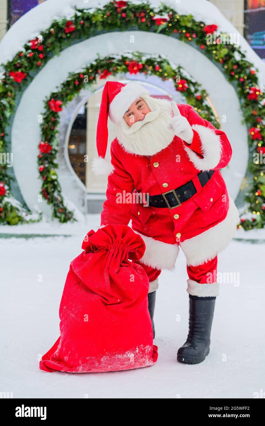 Santa Claus posing with a bag of gifts on the background of Christmas ...