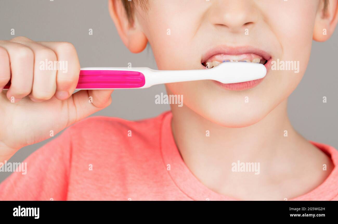 Kid boy brushing teeth. Boy toothbrush white toothpaste. Health care, dental hygiene. Joyful child shows toothbrushes. Little boy cleaning teeth Stock Photo