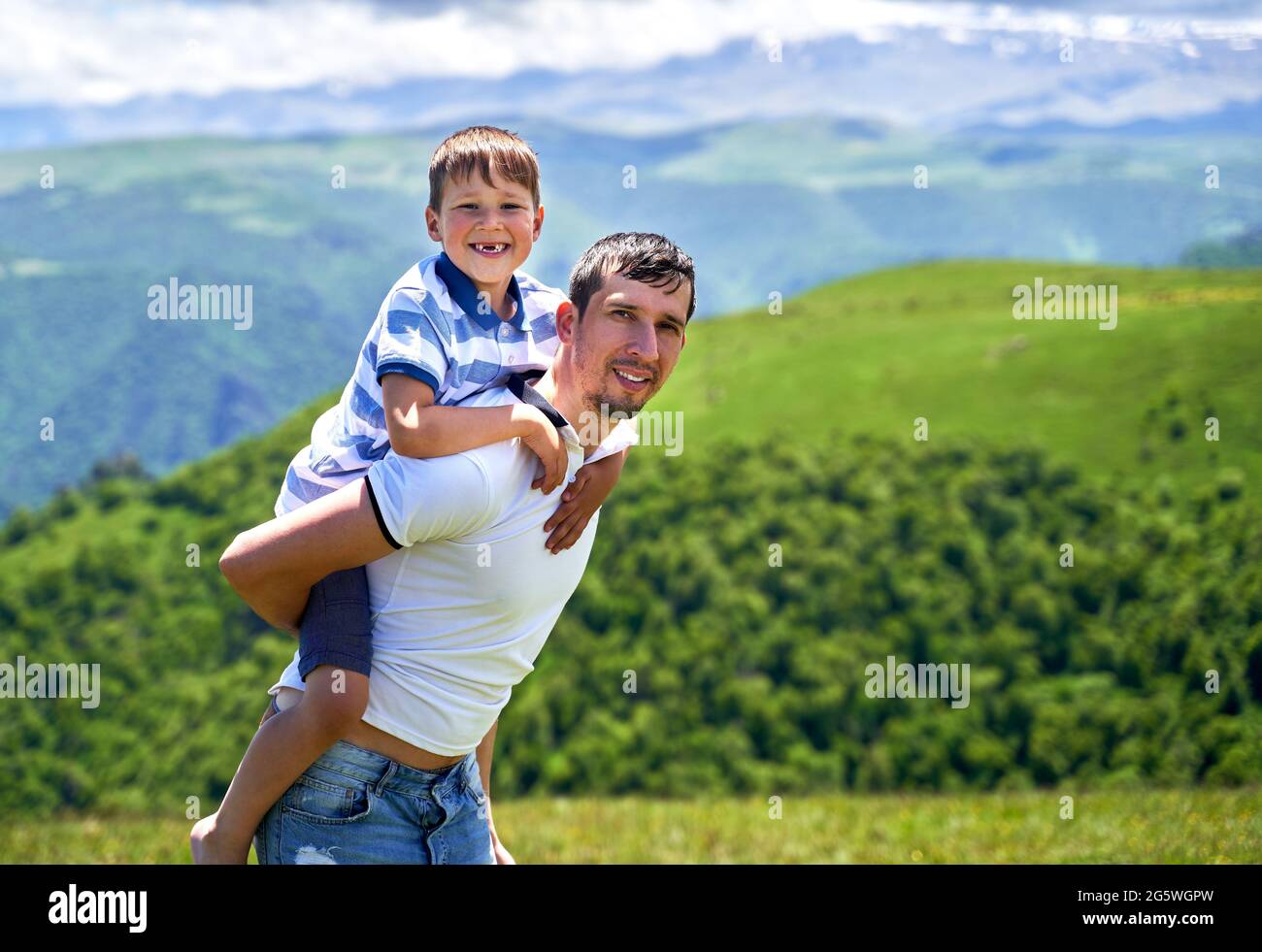 a child rides on his father's back Stock Photo