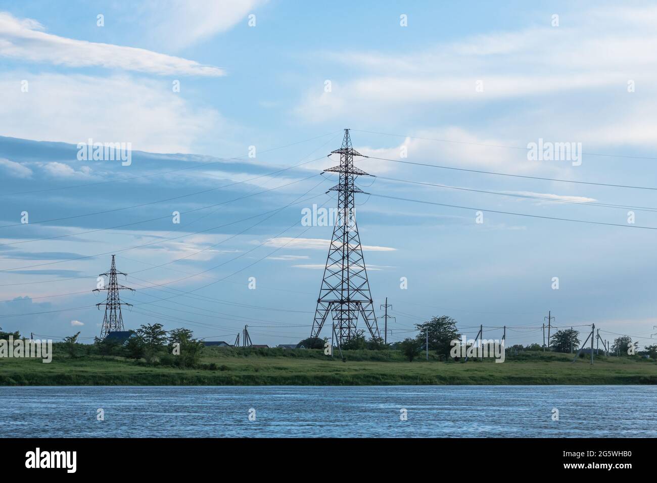 Two power transmission towers stand against the background of the river ...