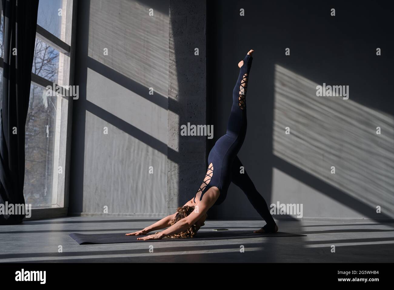 Young woman practicing yoga poses in an urban background on sunny day ...