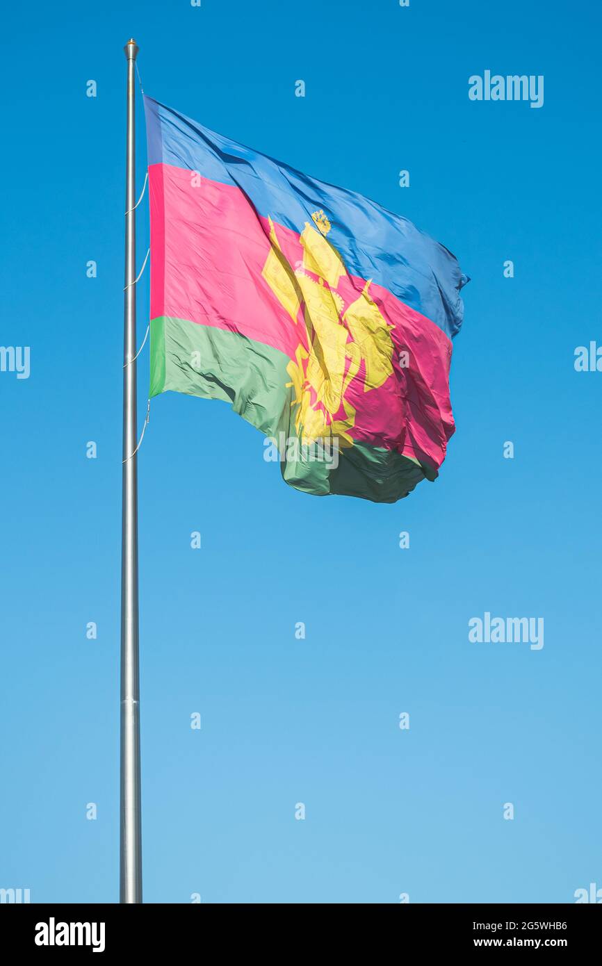 The flag with the coat of arms of the Krasnodar Territory flutters in the wind Stock Photo
