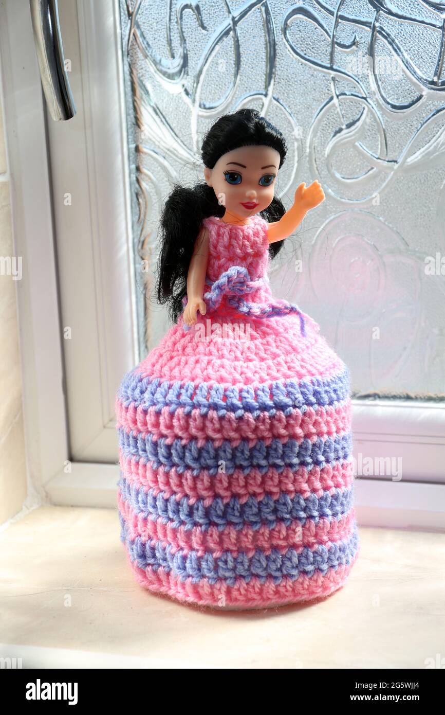 Toy doll with crochet dress which extends over a fresh roll of toilet paper  Stock Photo - Alamy