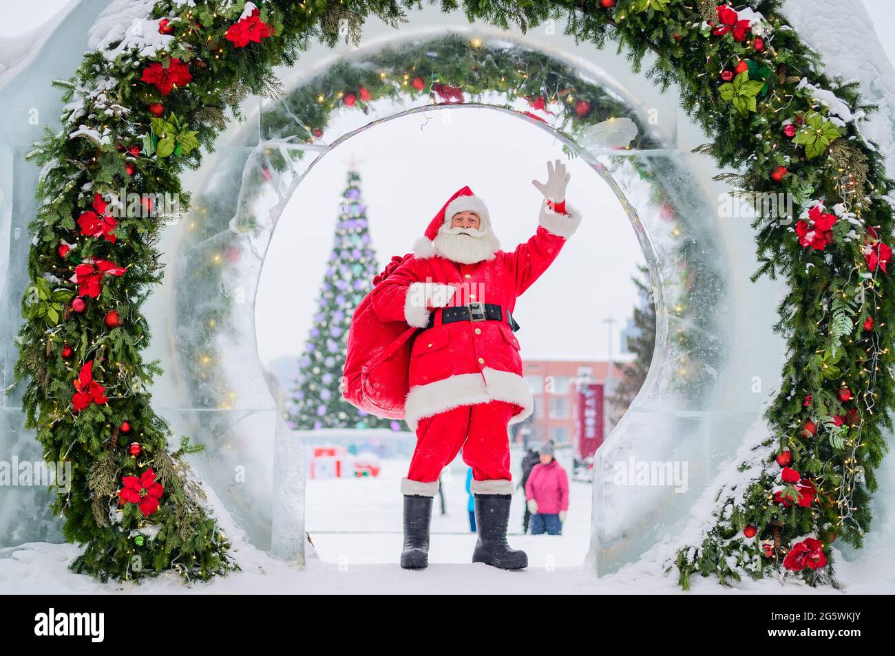 Santa Claus posing with a bag of gifts on the background of Christmas ...