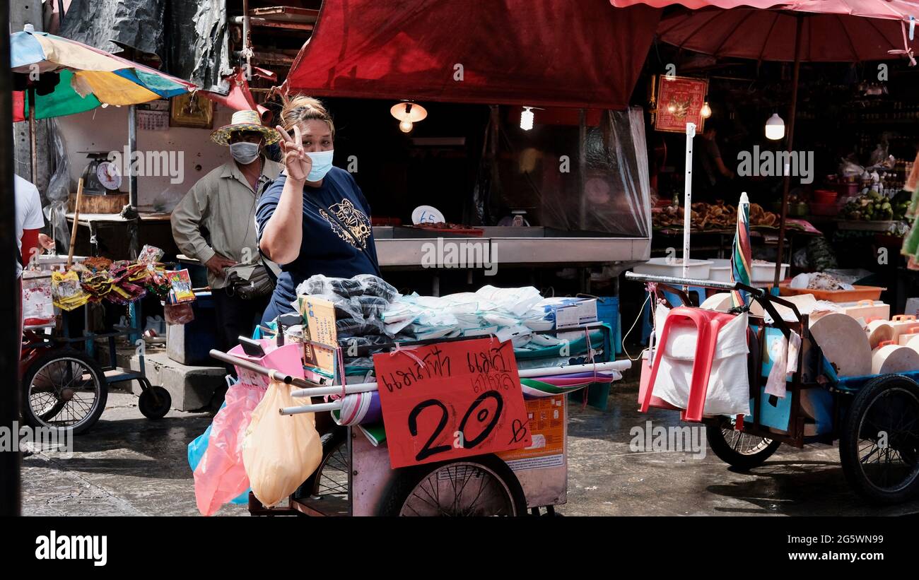 Lady Seller giving the peace sign Klong Toey Market Wholesale Wet Market Bangkok Thailand largest food distribution center in Southeast Asia Stock Photo