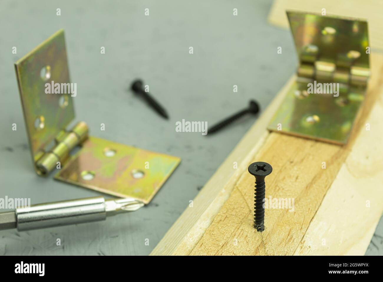 A black screw is screwed into the board. Carpenter's work process,  self-tapping screw is screwed into wood. Fastening screw for construction.  Backgrou Stock Photo - Alamy