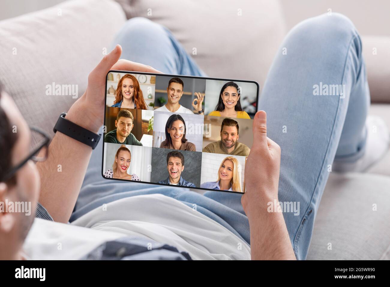 Man Having Group Video Chat With Friends While Relaxing With Digital Tablet  Stock Photo - Alamy