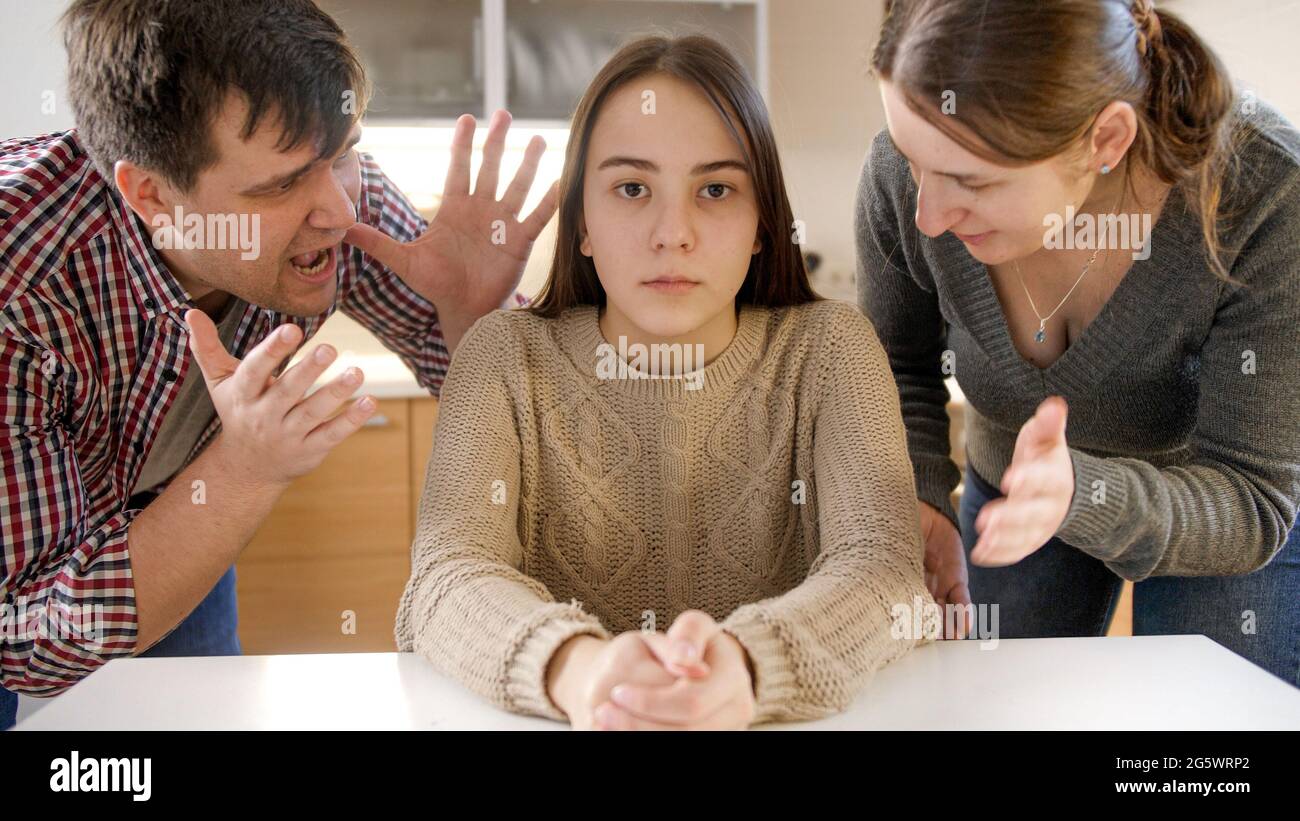 https://c8.alamy.com/comp/2G5WRP2/parents-yelling-and-shouting-at-teenage-daughter-sittin-behind-table-and-looking-in-camera-2G5WRP2.jpg
