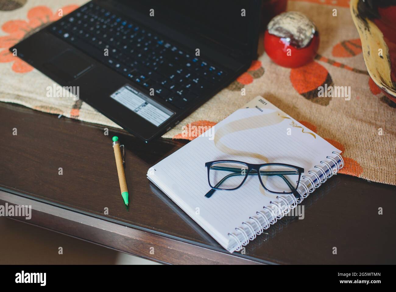 Hombre escribiendo en la mesa de madera planificando el analisis de negocio con la laptop, venta,compra, internet desde casa. Stock Photo