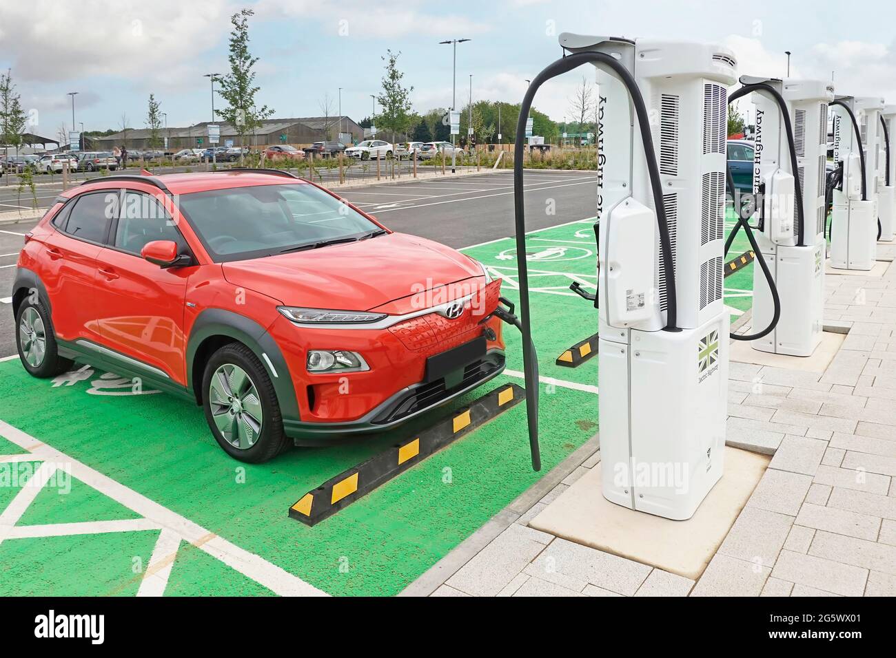 Climate change friendly electric car parking bay charging at one of Electric Highway chargers new MOTO Rugby services station M6 motorway England UK Stock Photo