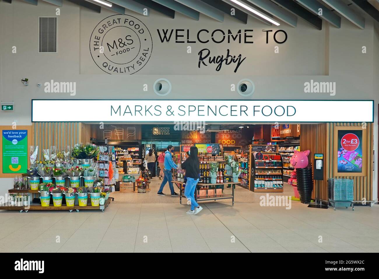 Welcome sign Marks & Spencer food shop front 2021 Moto Rugby M6 motorway services shopping mall shoppers in Covid face masks Warwickshire England UK Stock Photo