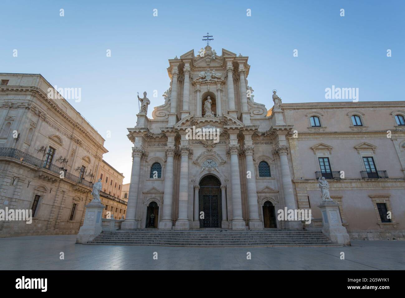Ortygia, Syracuse, Sicily, Italy. View across Piazza del Duomo to the richly decorated baroque façade of the cathedral, sunrise. Stock Photo