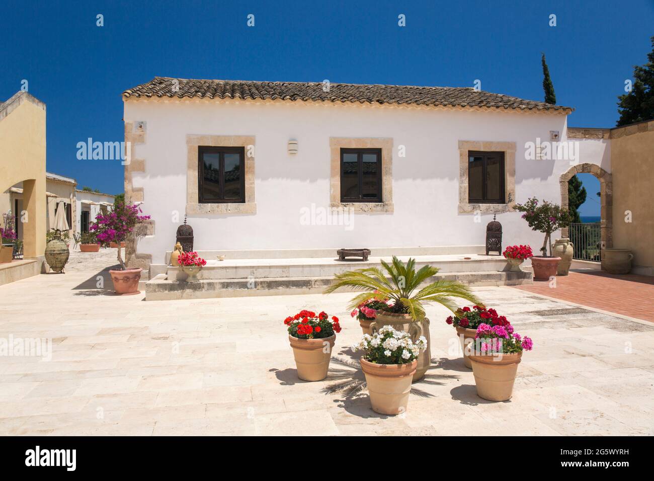 Noto, Syracuse, Sicily, Italy. View across sunlit courtyard of La Corte del Sole, a former 19th century masseria, now a boutique hotel. Stock Photo