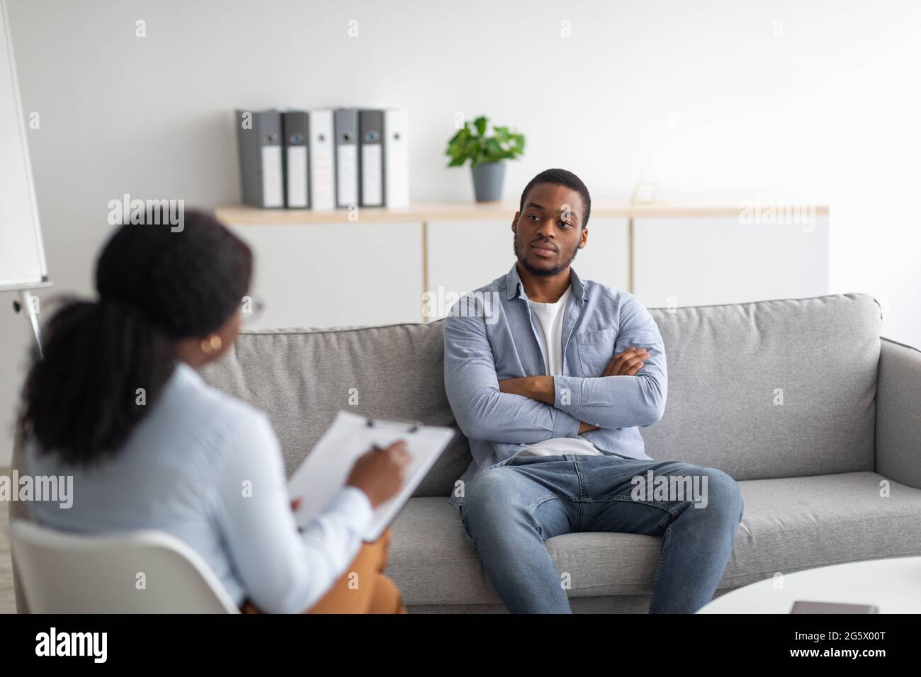 Psychological counselling. Black male patient with depression having session with psychotherapist at office Stock Photo