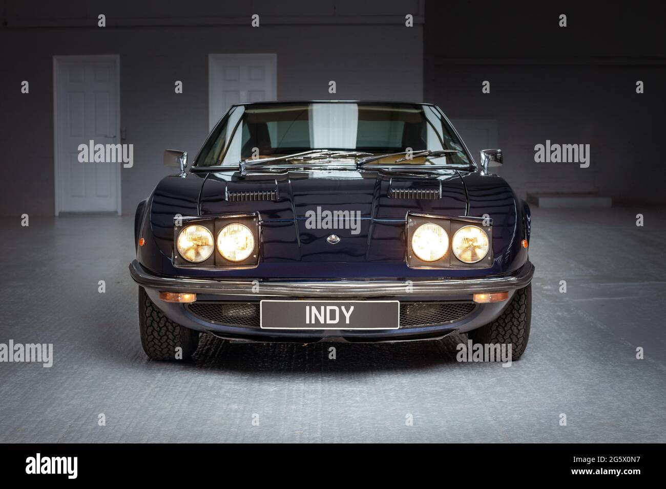 Front view with pop-up headlights of a blue 1971 Maserati 4700 Indy America V8 - Stock Image