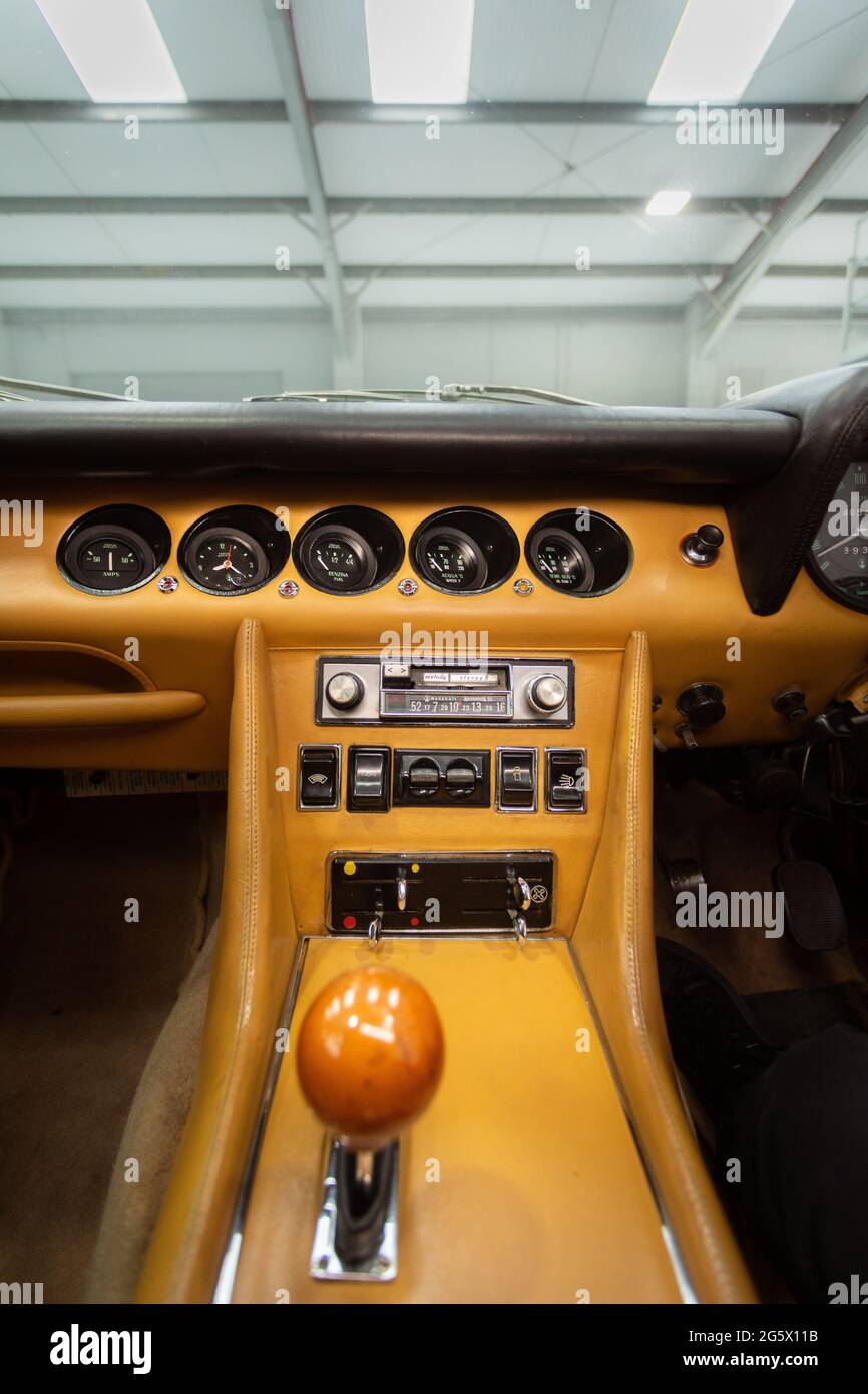Car interior showing central column with switchgear and row of dashboard dials in a 1971 Maserati 4700 Indy America V8 - Stock Image