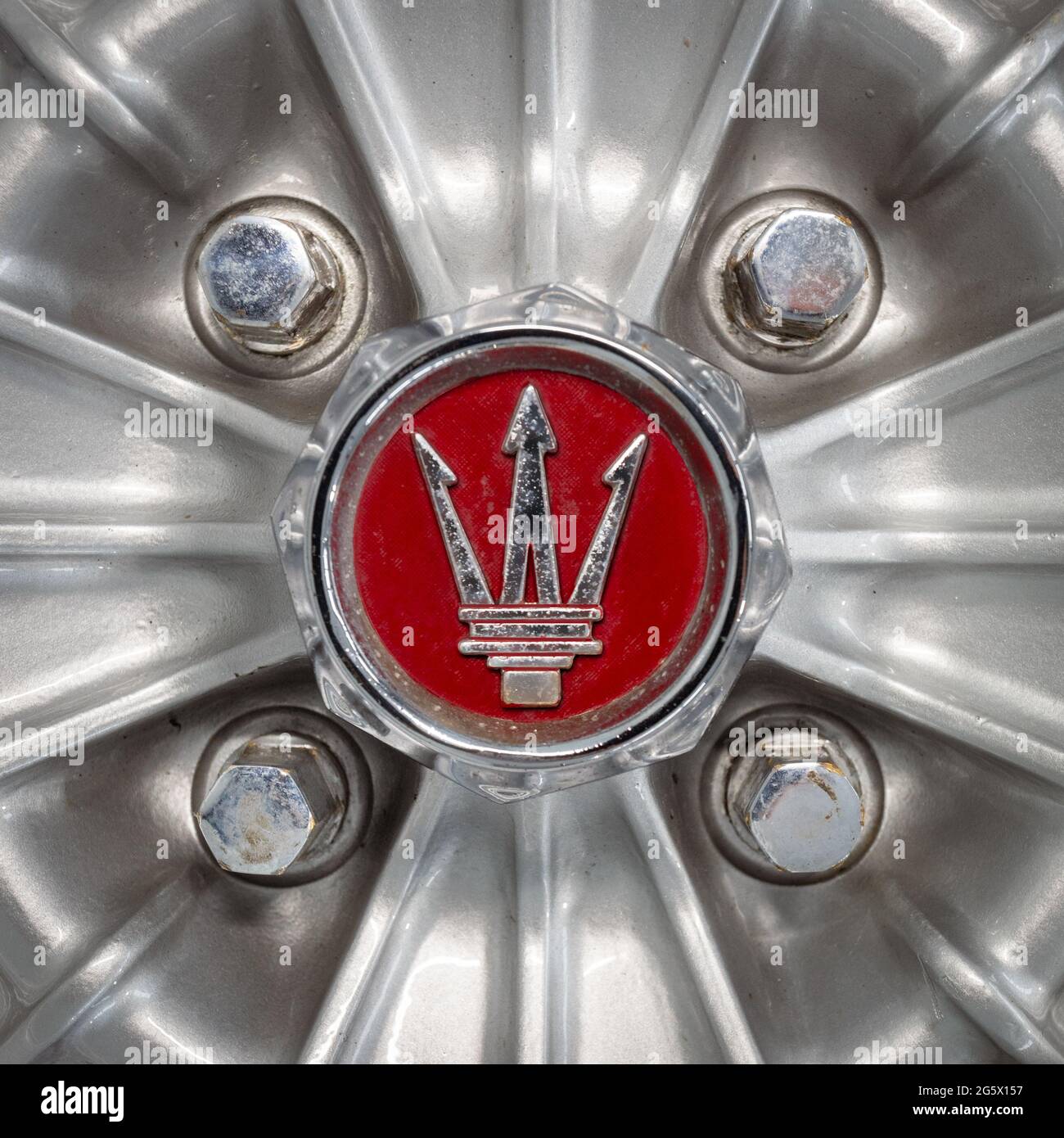 Detail of alloy wheel centre showing Maserati trident emblem on a blue 1971 Maserati 4700 Indy America V8 - Stock Image