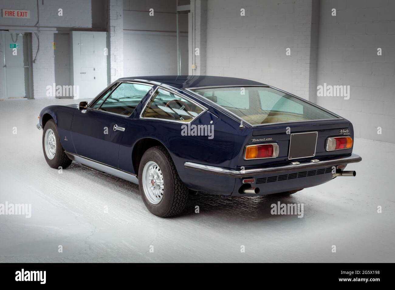 Rear quarter view of a blue 1971 Maserati 4700 Indy America V8 - Stock Image