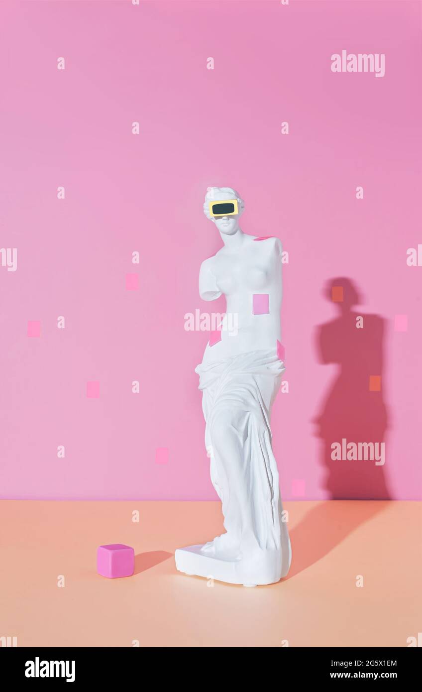 Creative layout with the VR goggles sculpture on an antique Venus on the colorful pink background. New technology digital gadget. Concept art with a m Stock Photo