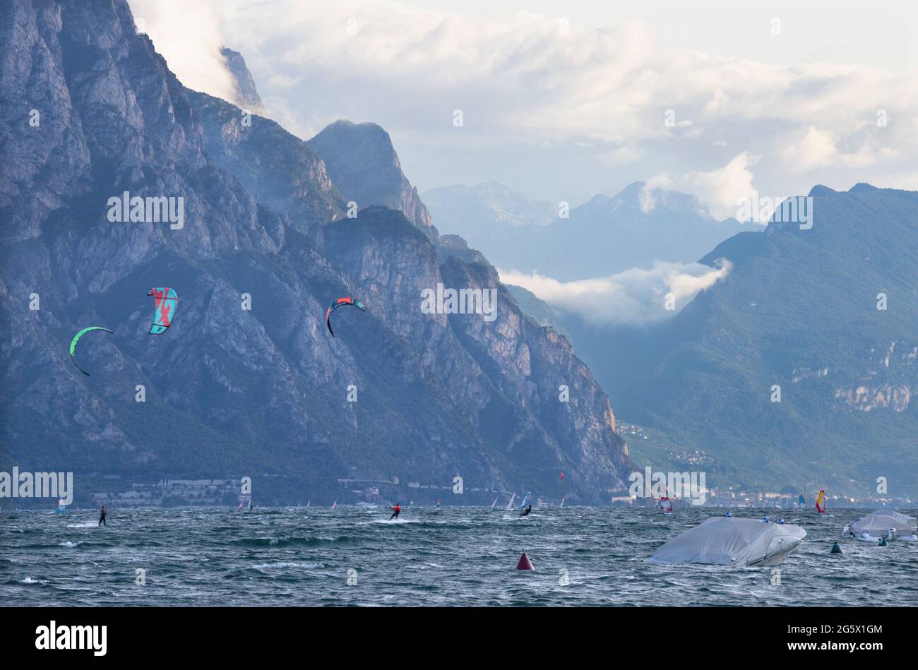 MALCESINE, ITALY - JUNE 13, 2019: The windsurfers on the Lago di Garda. Stock Photo