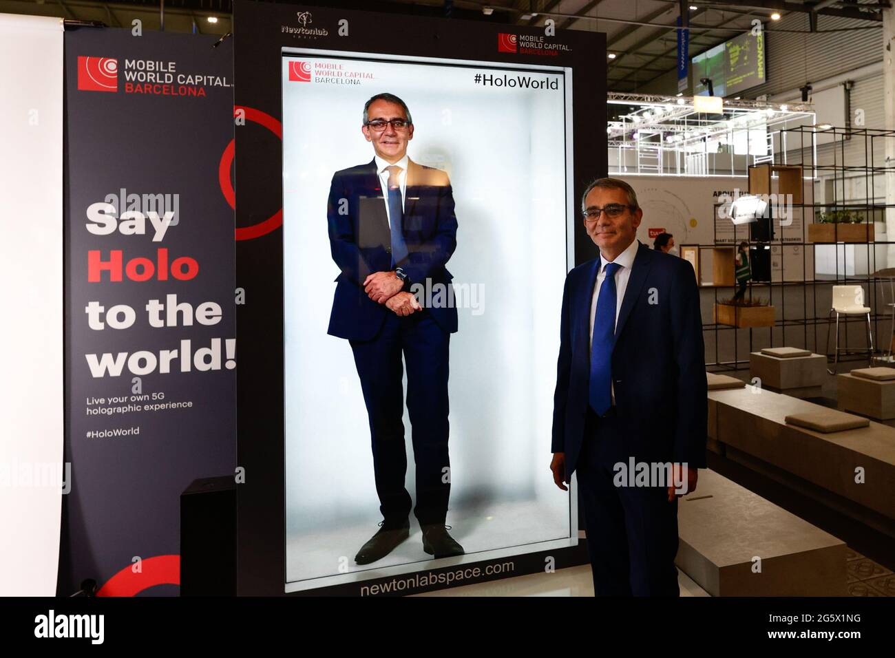 A congress visitor standing by a hologram of himselfduring the third day of Mobile World Congress. This technology, developed by Mobile World Capital Barcelona in collaboration with Vodafone and Newtonlab Space, allows the user to project an hologram of themselves in real time thanks to 5G.ÊAfter being suspended in 2020 due to the pandemic, the Mobile World Congress reopened again with notably fewer exhibitors and visitors. Nevertheless, the technology innovations are visible after two years. While 5G was still very recent on the 2019 edition and could only be seen applied by a reduced number Stock Photo