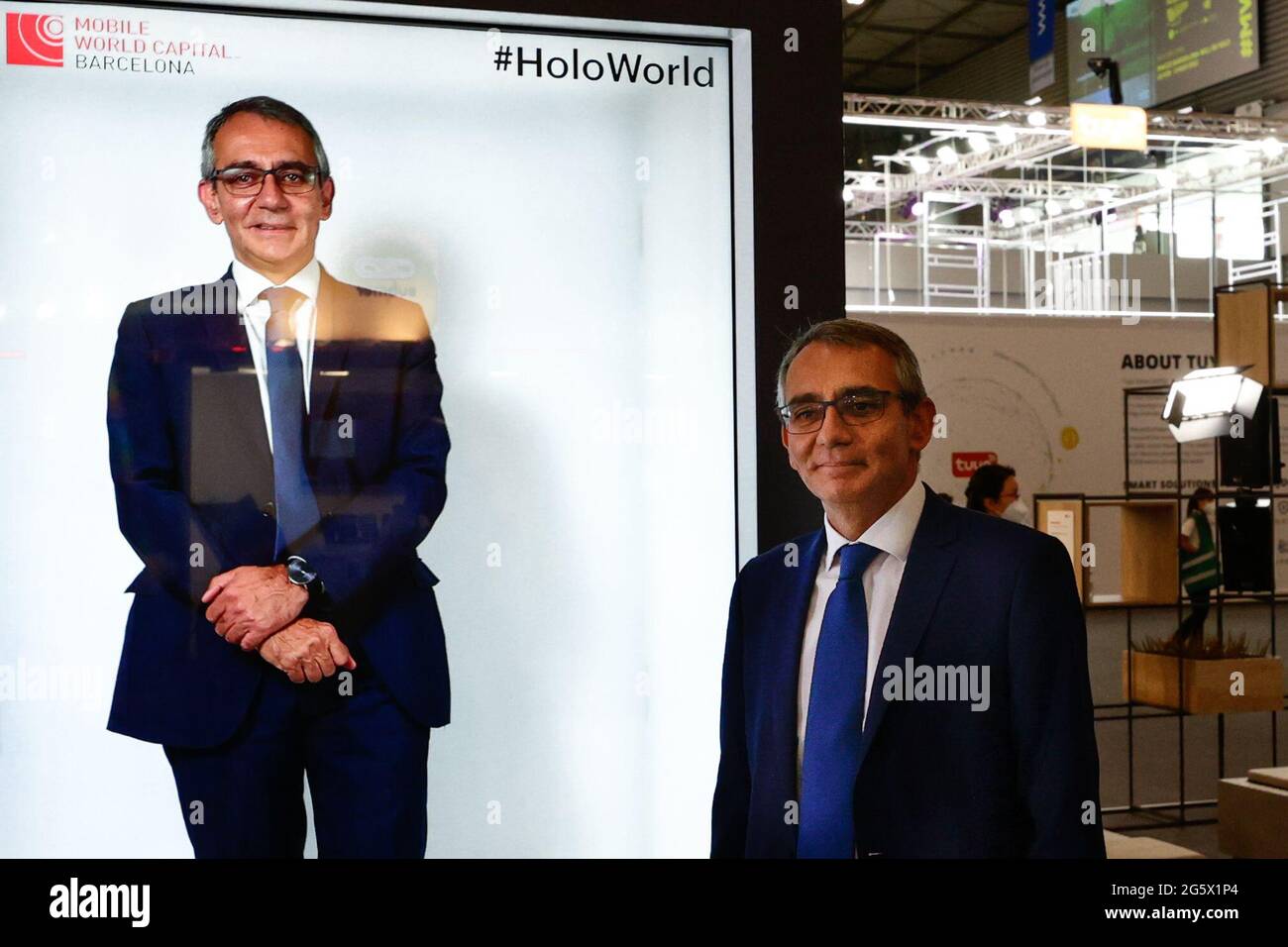 A congress visitor standing by a hologram of himselfduring the third day of Mobile World Congress. This technology, developed by Mobile World Capital Barcelona in collaboration with Vodafone and Newtonlab Space, allows the user to project an hologram of themselves in real time thanks to 5G.ÊAfter being suspended in 2020 due to the pandemic, the Mobile World Congress reopened again with notably fewer exhibitors and visitors. Nevertheless, the technology innovations are visible after two years. While 5G was still very recent on the 2019 edition and could only be seen applied by a reduced number Stock Photo