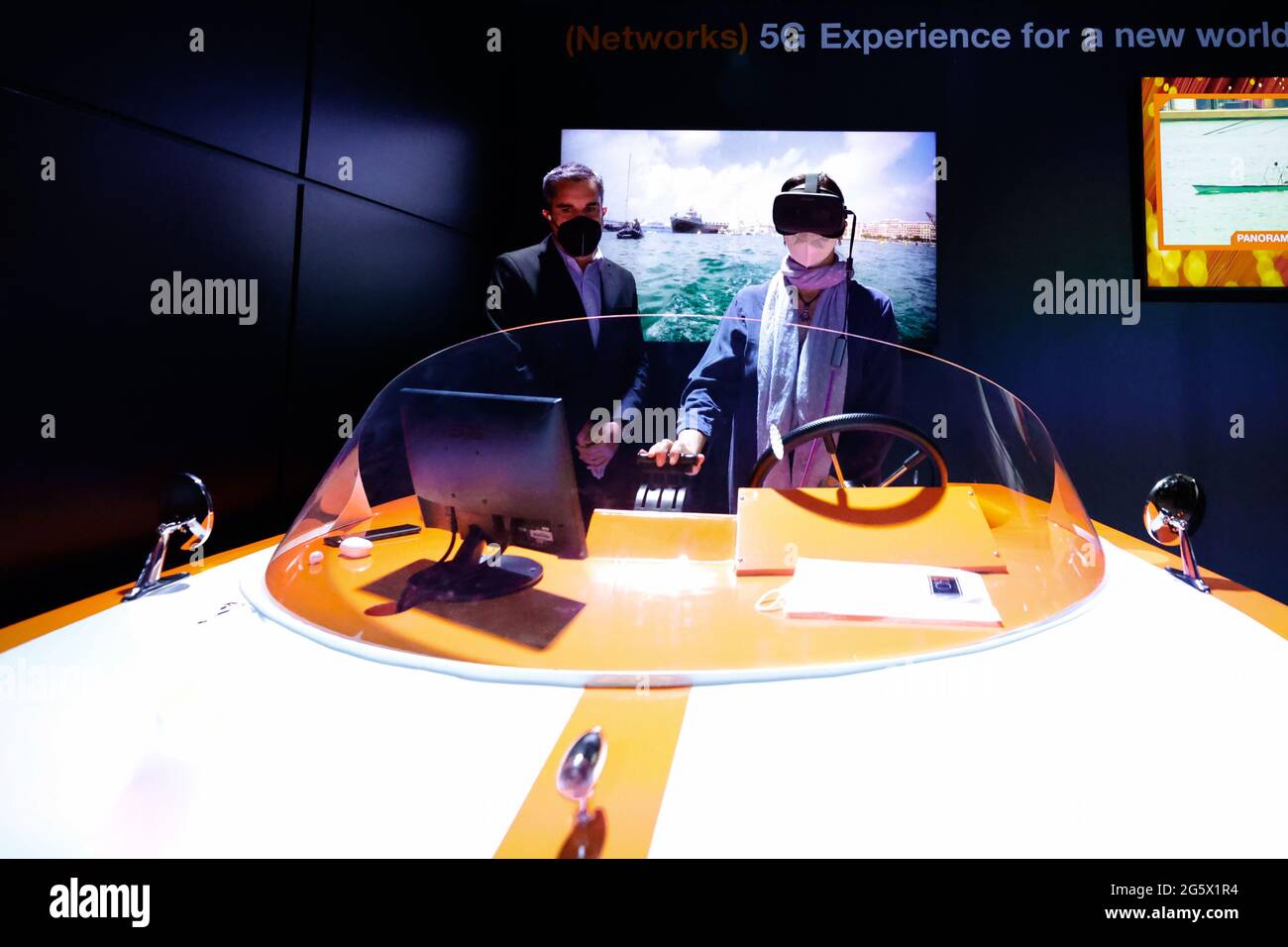 A congress visitor remotely controlling a marine drone while supervised by  an Orange attendant on the Orange stand of the Mobile World Congress,  during the third day of the event. Thanks to