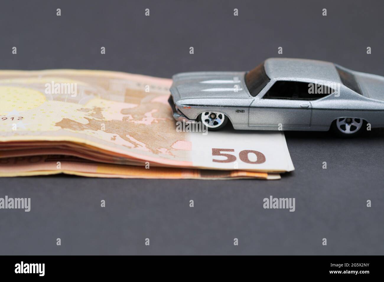 toy car rides up a stack of fifty euro banknotes Stock Photo