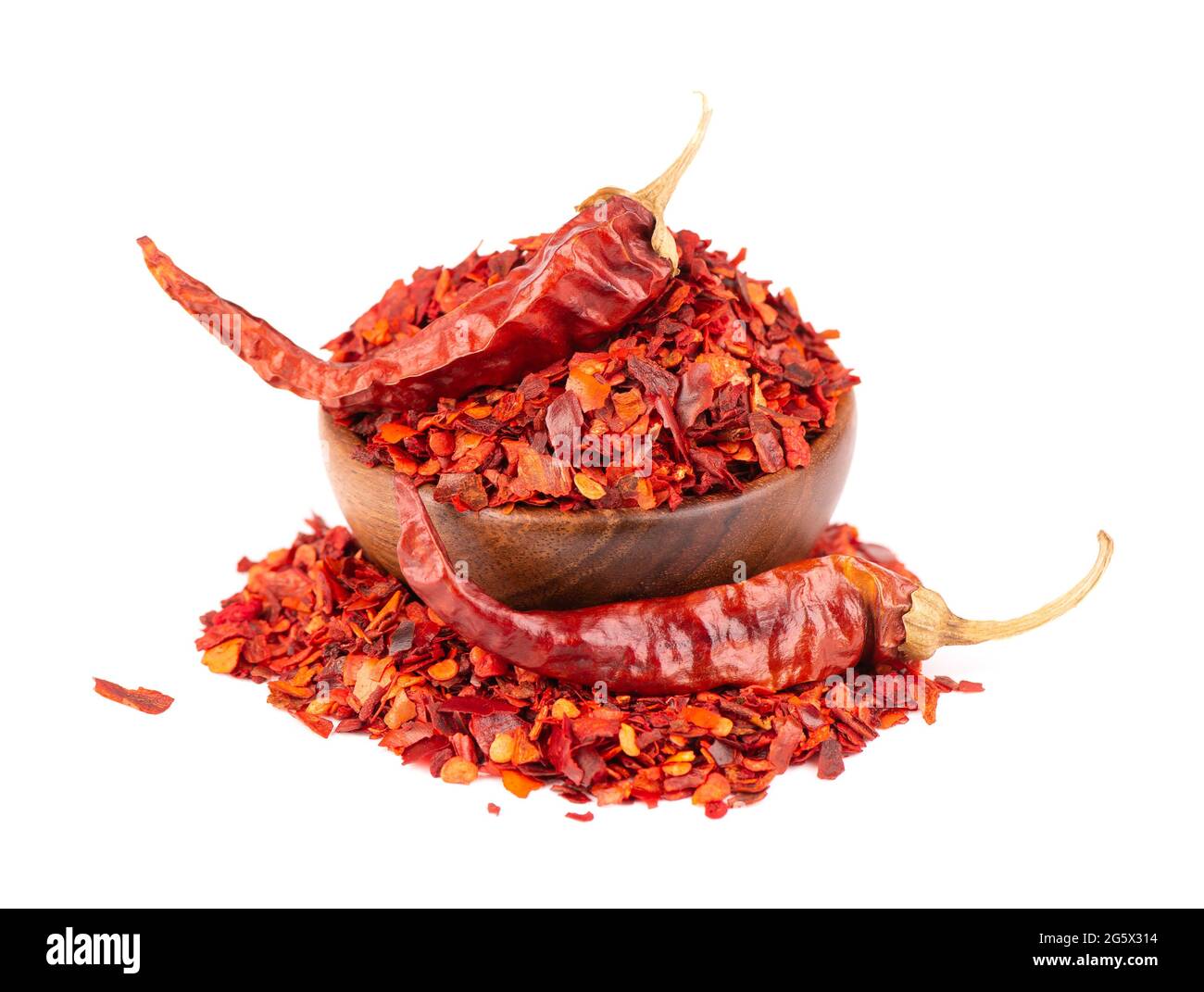 Dried red chili flakes in wooden bowl, isolated on white background. Chopped chilli cayenne pepper. Spices and herbs. Stock Photo