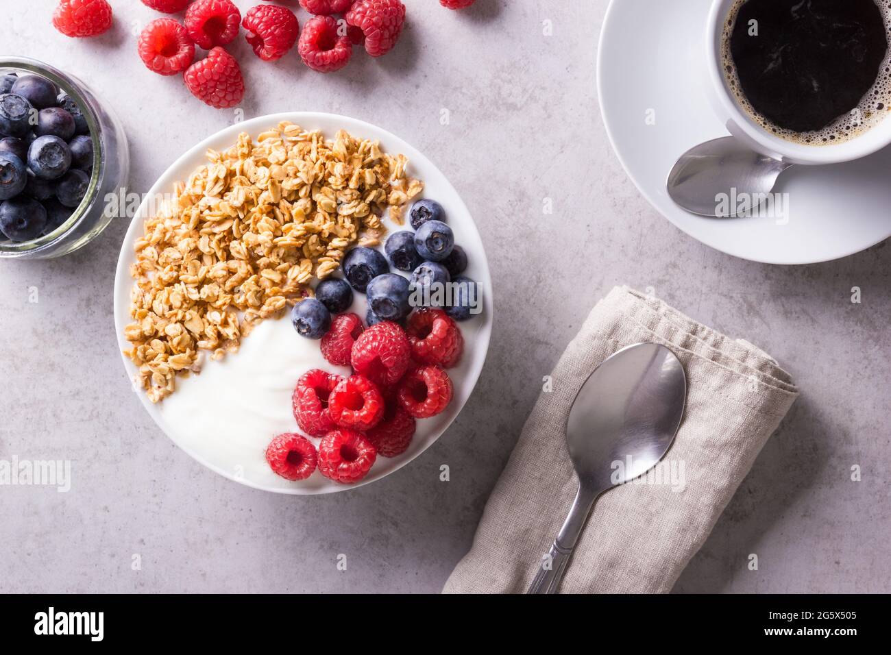 Breakfast consisting of plain yogurt garnished with berries and granola