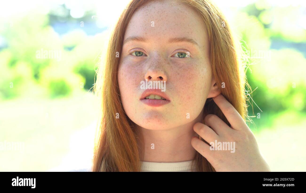Portrait a smiling young woman with red hair and freckles against the ...