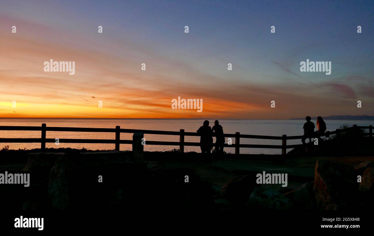 Two couples watching the sun set into the Pacific Ocean Stock Photo - Alamy