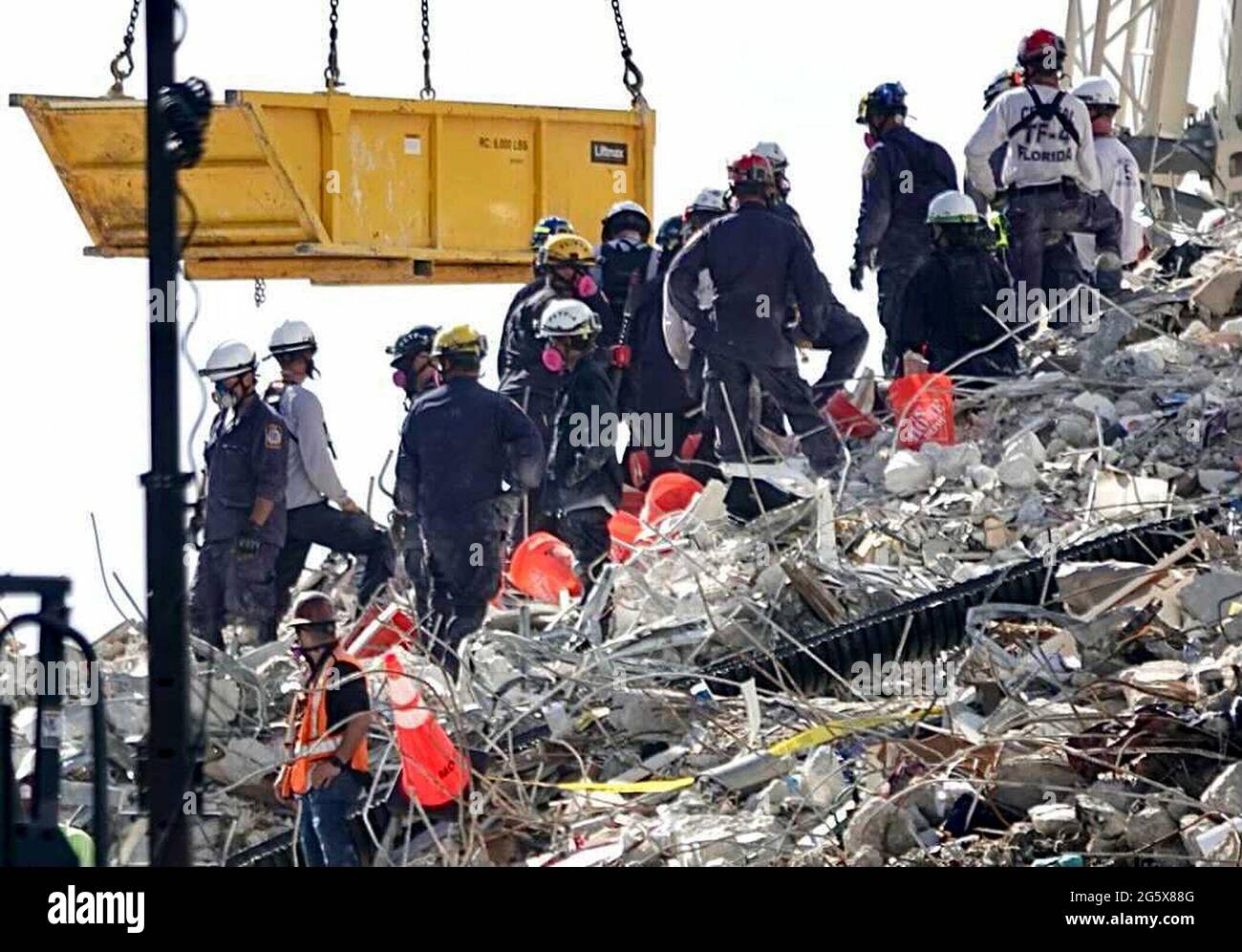 USA. 29th June, 2021. A bucket brigade works to remove debris from the