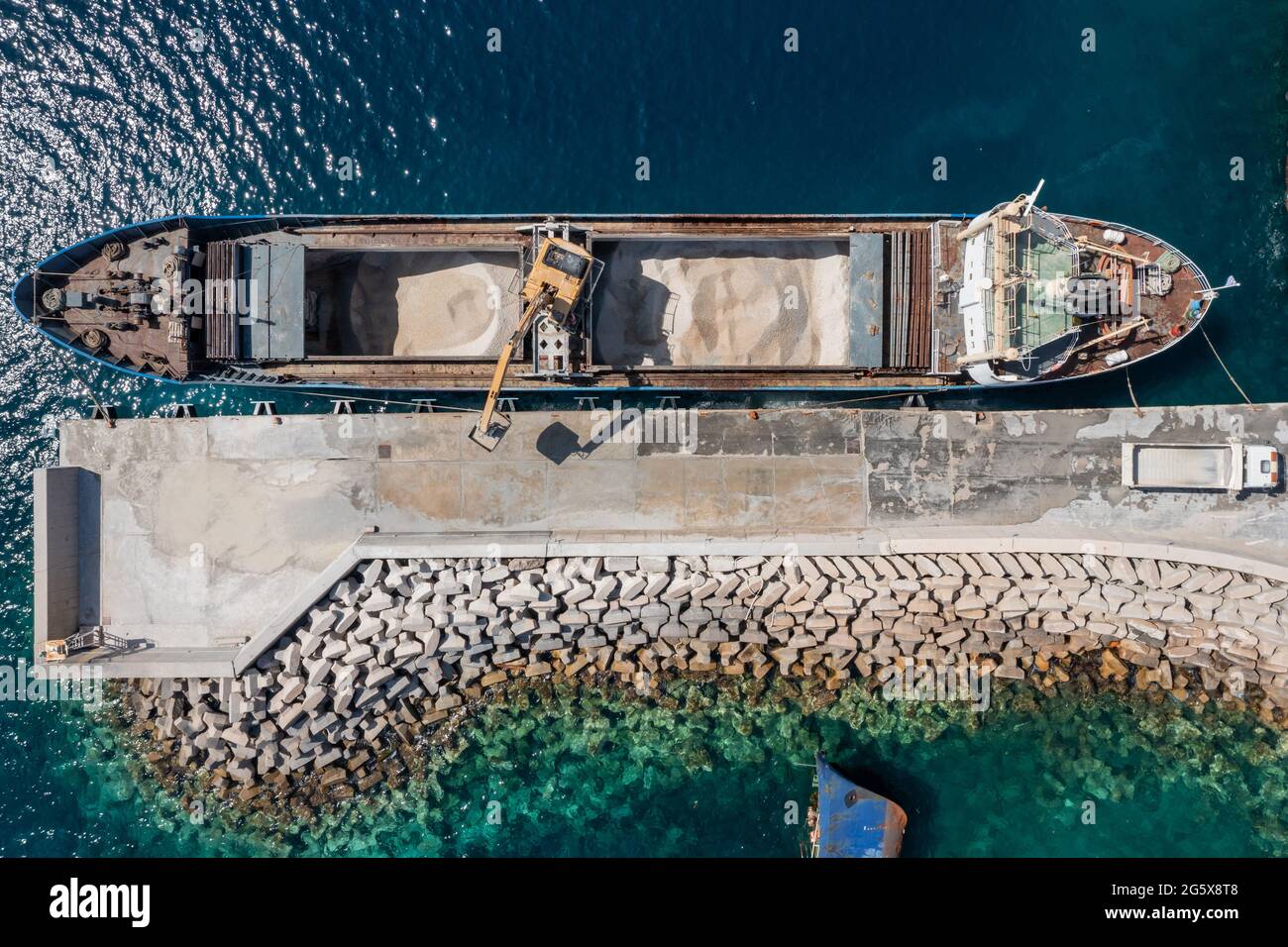 Marine works construction equipment and machinery, aerial drone top down view, Sand loading machine on a ship at Korissia port, Kea Tzia island, Cycla Stock Photo